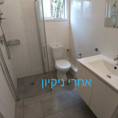 חדר אמבטיה נקי עם מקלחת ושירותים