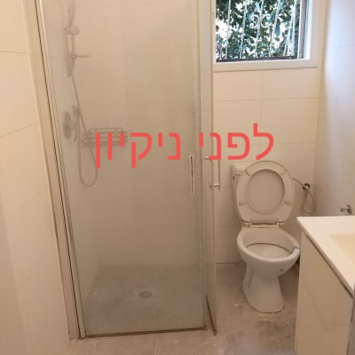 חדר אמבטיה עם מקלחון ושירותים לפני ניקיון