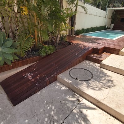 רמפת עץ ליד בריכה עם צמחייה מסביב