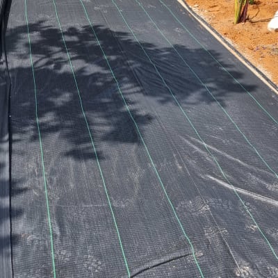 בד גינון שחור פרוס על הקרקע בגינה