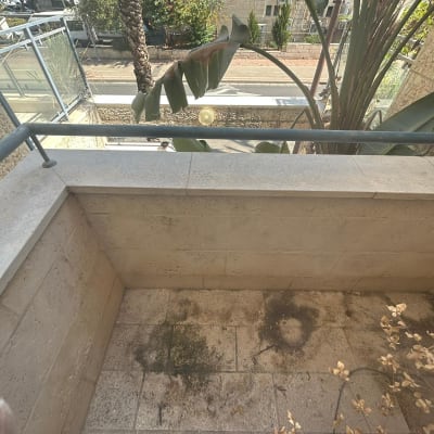 מרפסת עם קיר אבן ורצפה מלוכלכת