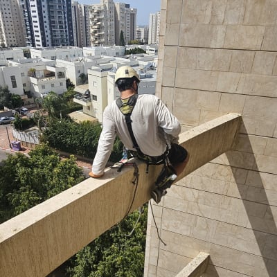 אדם עם ציוד בטיחות על קורת בניין