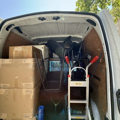 משאית עם קרטונים וציוד הובלה, סולם וארגזים.