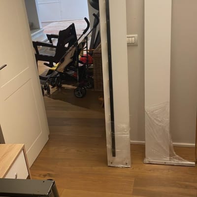 חלקי רהיטים ארוזים בפלסטיק על רצפת עץ