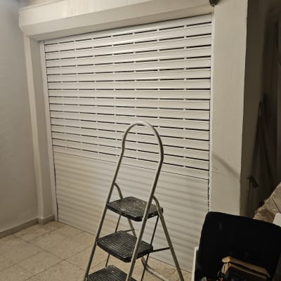 תריסים לבנים סגורים עם סולם וכלי עבודה