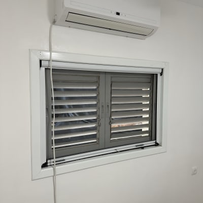 קיר צבוע בלבן עם מזגן וחלון