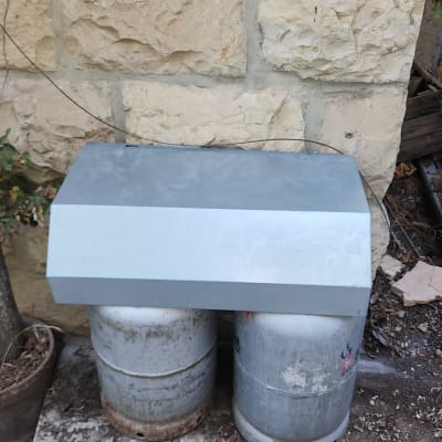 שני בלוני גז עם כיסוי מתכת ליד קיר אבן