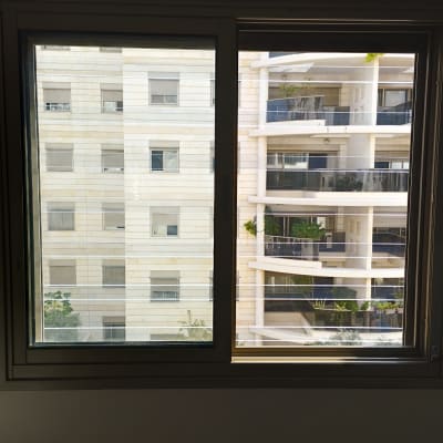 חלון אלומיניום עם נוף לבניינים סמוכים