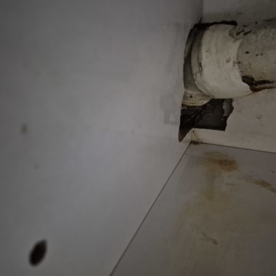 צינור עם סימני חלודה ונזק בקיר
