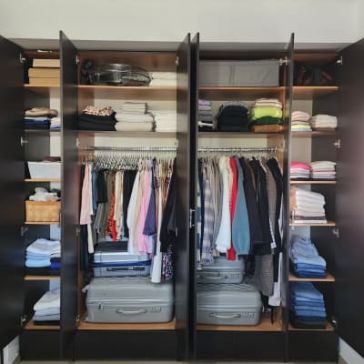 ארון בגדים מסודר עם מדפים, בגדים ומזוודות