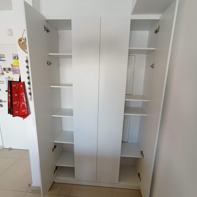 ארון לבן עם דלתות פתוחות ומדפים פנימיים