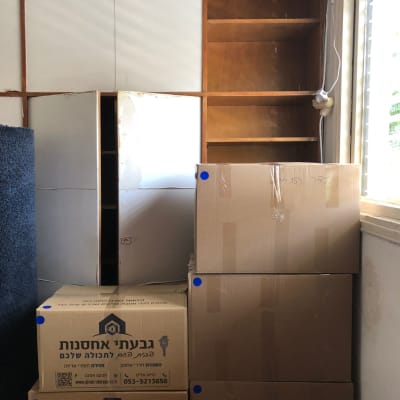 קופסאות קרטון מסודרות ליד מדפים ריקים