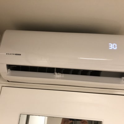 מזגן קיר לבן עם תצוגת טמפרטורה 30 מעלות