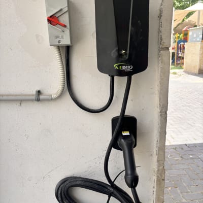 מטען לרכב חשמלי מותקן על קיר עם כבל טעינה