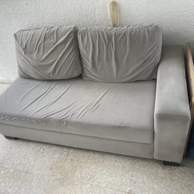 ספה אפורה עם כריות על רצפת אריחים