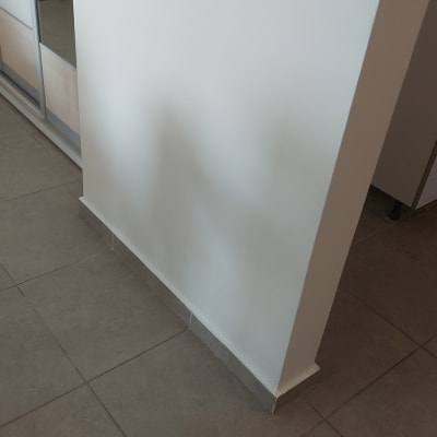 קיר צבוע ולבן עם רצפת אריחים אפורה