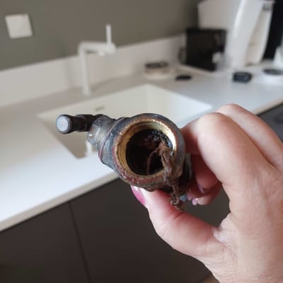 שסתום חלוד עם הצטברות לכלוך ביד אדם