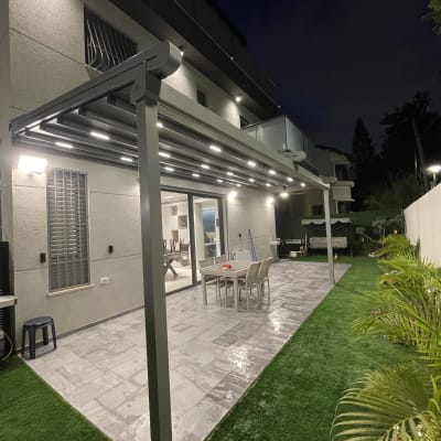 פרגולה מאלומיניום בחצר עם תאורה בלילה