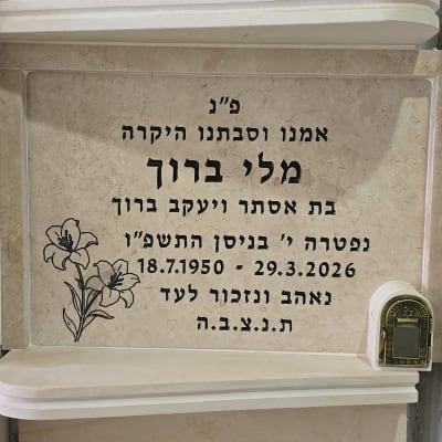 מצבה עם כיתוב בעברית ופרחים חקוקים