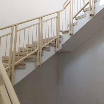 מדרגות עם מעקה מתכת בצבע בז