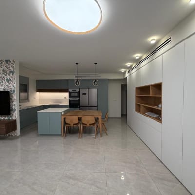 מטבח מודרני עם אי, ארונות ותאורה מעוצבת