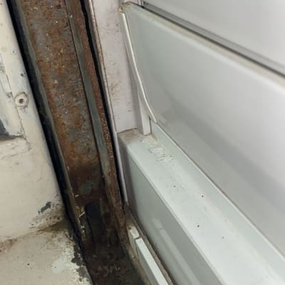 תריסים לבנים עם מסגרת מתכת חלודה