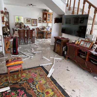 חדר מבולגן עם שטיח צבעוני ופסולת על הרצפה