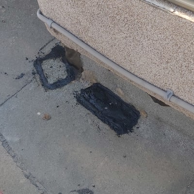 איטום עם חומר שחור על קיר ובטון