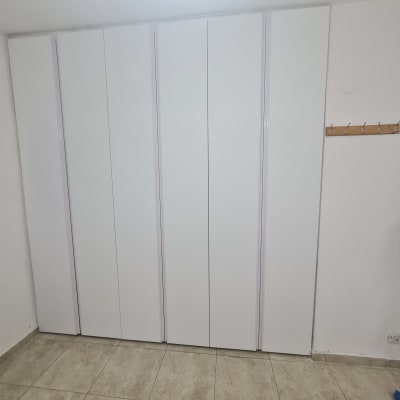 ארון לבן עם דלתות סגורות על רצפת קרמיקה