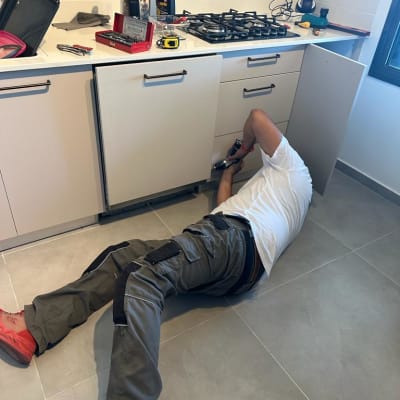 אדם מתקן ארון מטבח עם מברגה חשמלית