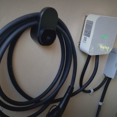 מטען לרכב חשמלי מותקן על קיר עם כבל שחור