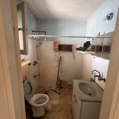 חדר אמבטיה ישן עם שירותים, כיור ומקלחת