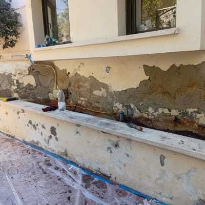 עבודת שיקום ואיטום קיר חיצוני בבית קרקע לאחר קילוף טיח פגום