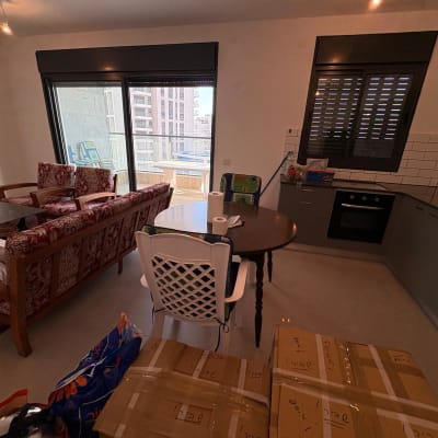 סלון ומטבח עם ארגזים, שולחן וכיסאות