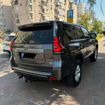 רכב טויוטה לנד קרוזר חונה ברחוב ליד בניינים