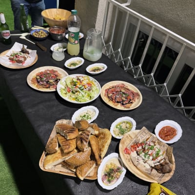 מגוון מנות על שולחן קייטרינג עם סלטים ולחמים.