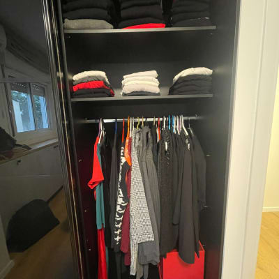 ארון בגדים מסודר עם בגדים מקופלים ותלויים