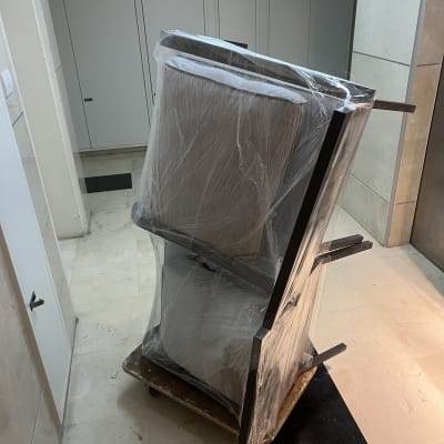 רהיטים עטופים בניילון על עגלה במסדרון בניין