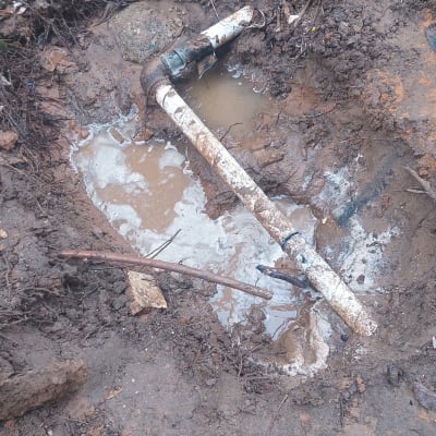 צינור מים שבור באדמה בוצית