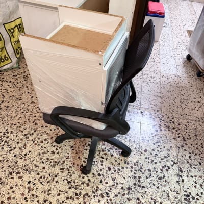 שידת משרד עטופה בשרינק מוכנה להובלה על כיסא משרדי