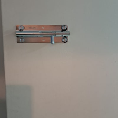 בריח מתכת על דלת עץ בצבע בהיר