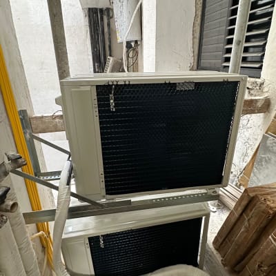 שני מזגנים מותקנים על קיר חיצוני עם צינורות מחוברים