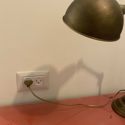 מנורה מחוברת לשקע חשמלי על קיר לבן