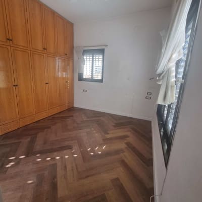 רצפת פרקט עץ בדוגמת פישבון בחדר מואר