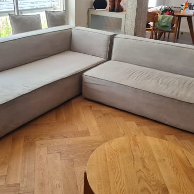 ספה אפורה בחדר מגורים עם רצפת עץ