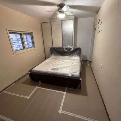 חדר מוכן לצביעה עם כיסוי ניילון על המיטה