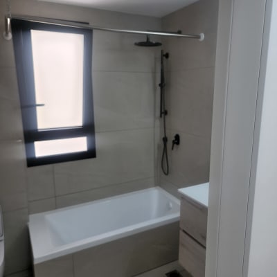 חדר אמבטיה עם אמבטיה ומקלחת נקיים