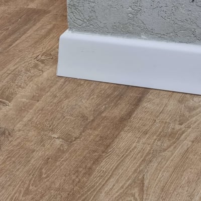 רצפת פרקט עץ ליד קיר עם פנל לבן