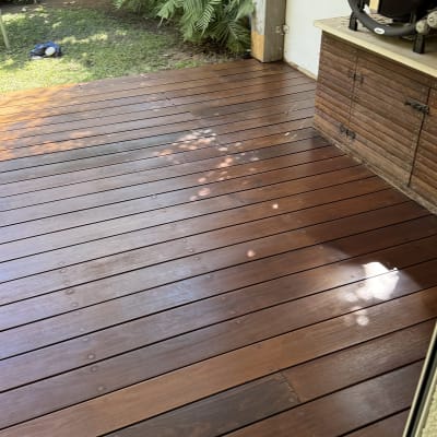 דק עץ עם גריל על שולחן עץ ליד גדר במבוק