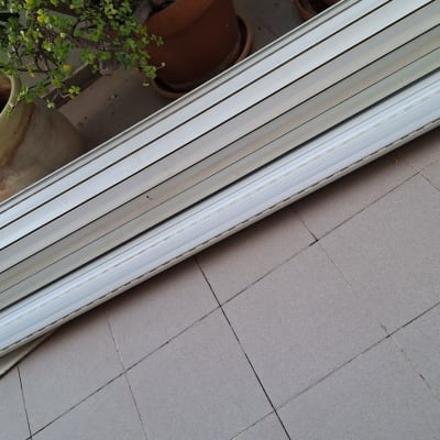 תריסים מונחים על רצפה ליד עציץ